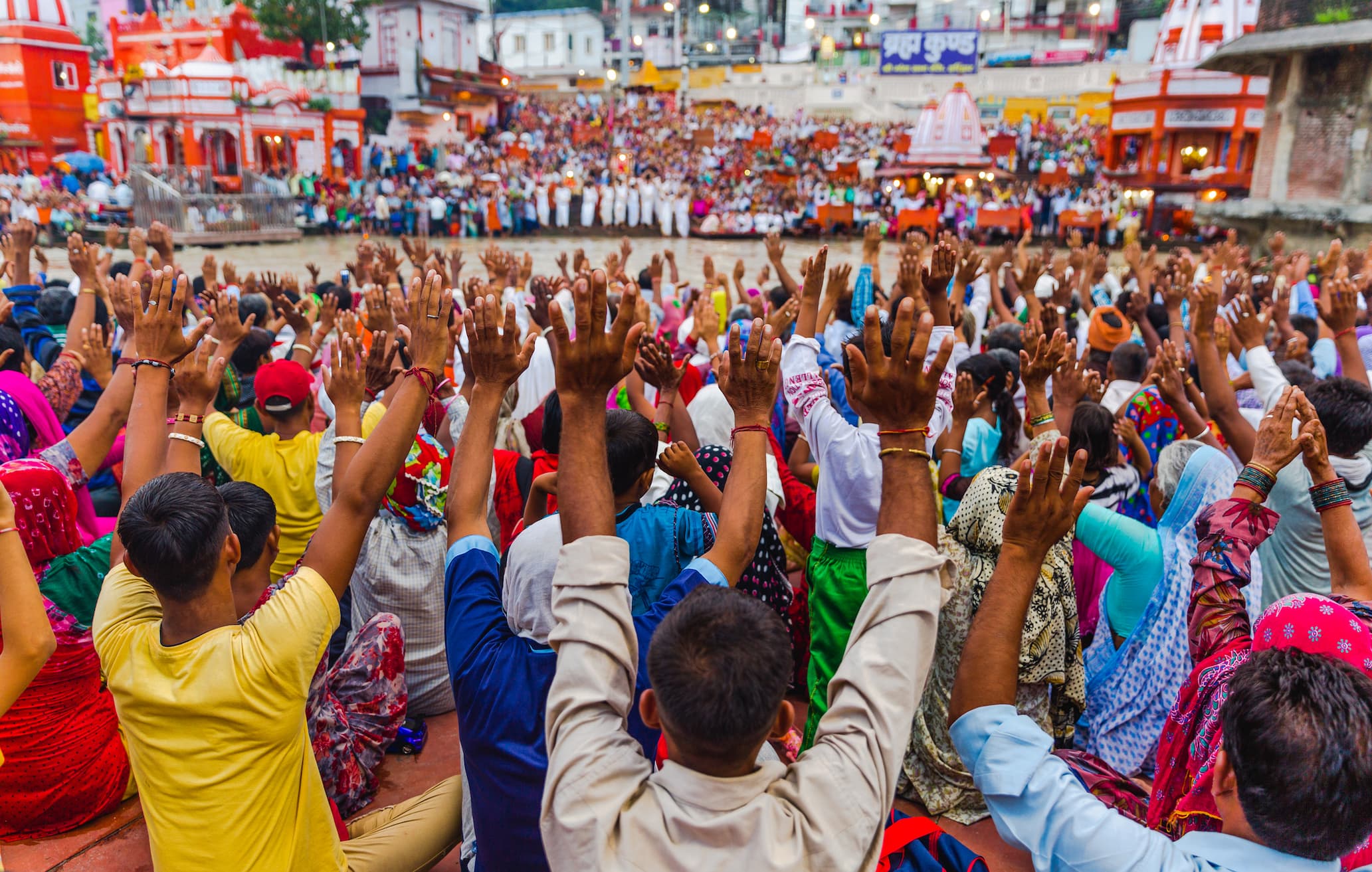 Crowds raising hands in prayer during the Ganga Aarti at Har Ki Pauri ghat, Haridwar